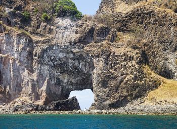 Rock formations by sea against sky