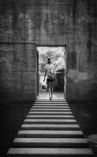 Rear view of woman walking on wall
