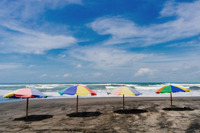 Four beach umbrellas agains blue sky