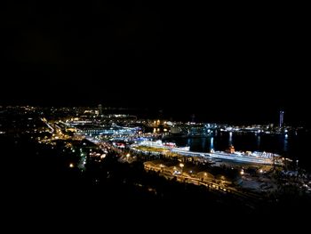 Aerial view of illuminated cityscape against clear sky at night