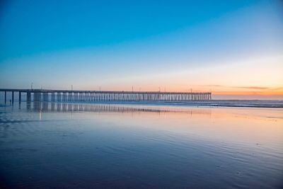 Pier on sea against sky during sunset