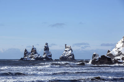 Three pinnacles of vik with rough waves, south iceland in wintertime