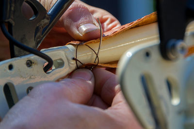 Close-up of hands sewing bicycle seat