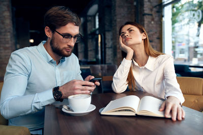 Young couple sitting on table at cafe