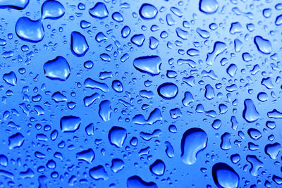Full frame shot of raindrops on blue water