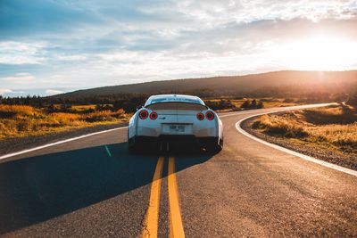 Car on road against sky during sunset