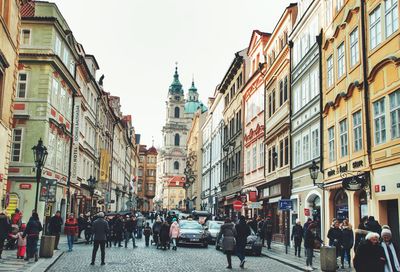 People walking on street amidst buildings in city