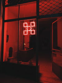Illuminated text on red door of building at night
