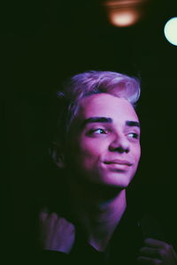 Close-up of smiling teenage boy looking away