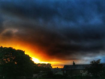 Storm clouds over buildings during sunset