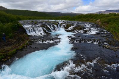 Scenic view of waterfall against sky