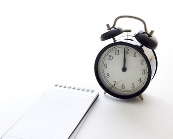 Close-up of clock on table against white background