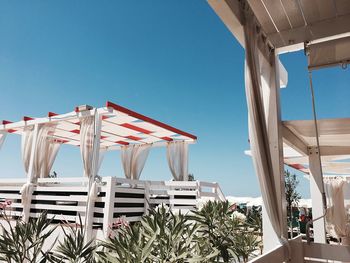 Low angle view of pergola against clear blue sky