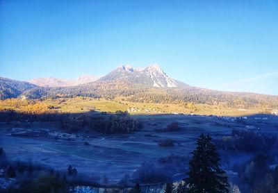 Scenic view of snowcapped mountains against clear blue sky