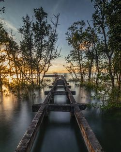 Bridge over lake against sky during sunset