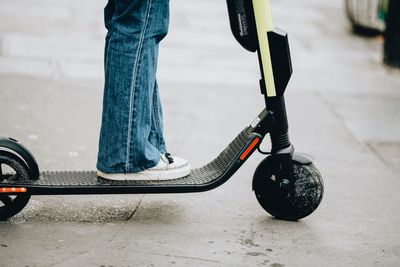 Low section of person skateboarding on street