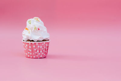 Close-up of ice cream cone against pink background