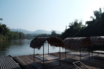 Built structure against trees and mountains against clear sky