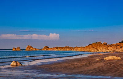 Scenic view of beach against blue sky