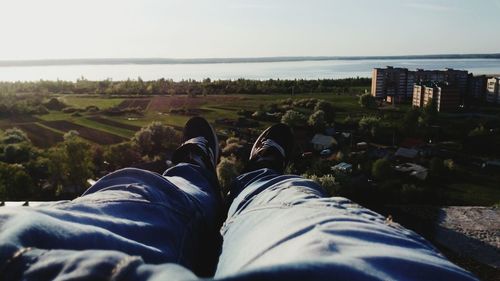 Low section of man on landscape against sky