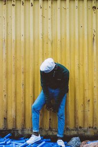 Rear view of person standing against wall