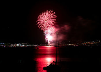 Firework display over river at night