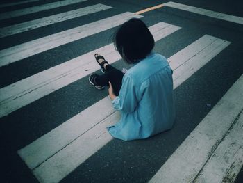 Rear view of man with umbrella on road