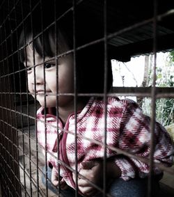 Cute smiling girl looking through fence