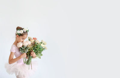 Woman holding flower bouquet against white background