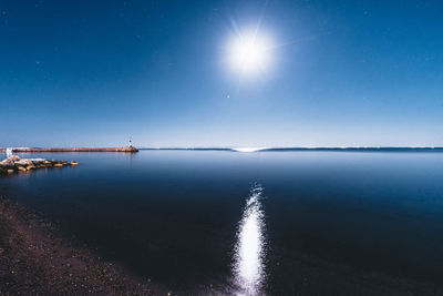 Scenic view of sea against bright sun