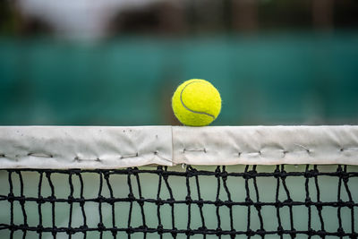 Close-up of tennis ball on net