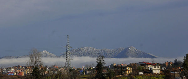 Panoramic view of traditional town, panga against  snow capped hills and sky