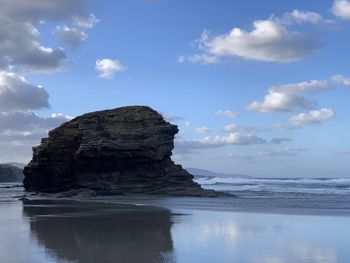 Rock formation in sea against sky