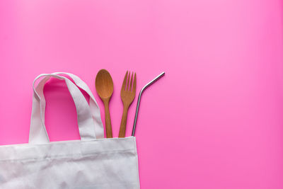 Close-up of woman against pink background