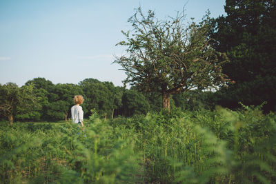 Woman standing on field against sky