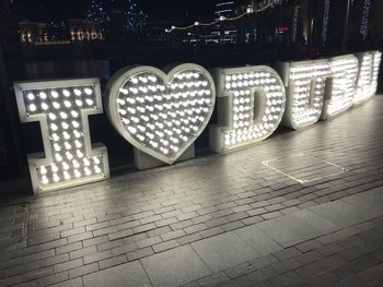 Text written on illuminated floor in city at night