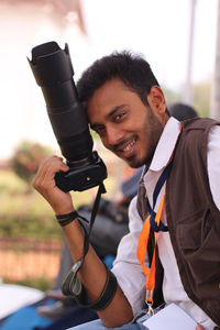 Portrait of smiling man holding camera