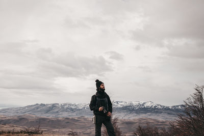 Man standing on mountain against sky