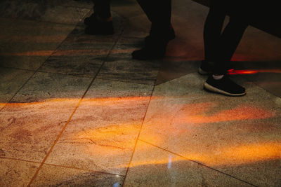 Low section of people walking on tiled floor