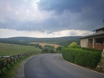 Road amidst green landscape against sky