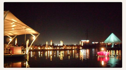 View of river with illuminated buildings in background