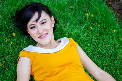 Portrait of young woman sitting on grassy field