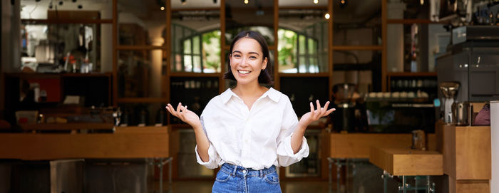 Portrait of young woman standing in library