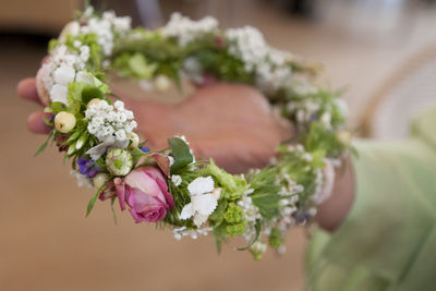 Cropped hand of woman holding wreath