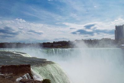 Scenic view of waterfall against sky