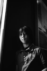 Low angle view of boy looking through window