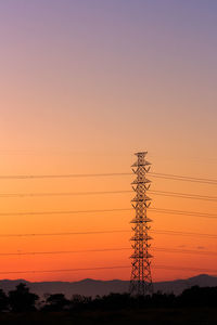 Low angle view of silhouette electricity pylon against romantic sky