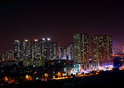 Illuminated buildings against sky at night