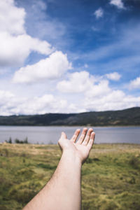 Cropped hand of man reaching sky