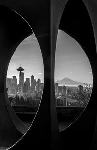 Space needle against sky in city seen through window